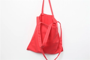Detail of red heavy canvas tote bag with white contrast stitching and versatile straps