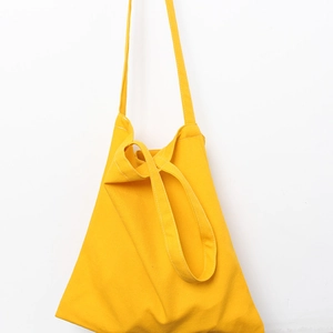 Detail view of bright yellow canvas tote bag with reinforced long shoulder straps