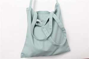 Detail view of mint green cotton canvas tote bag with triple shoulder strap design