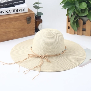 Classic beige wide-brim straw hat with decorative cord and beads for summer beach sun protection