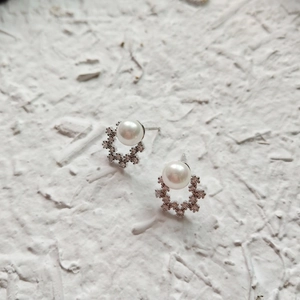 Close-up of S925 silver stud earrings featuring white pearls and cubic zirconia stones