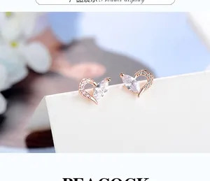 Macro shot of rose gold heart earrings featuring sparkling marquise zircon stones