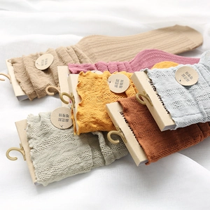 Detail of cable knit crew socks with lettuce trim in a variety of soft pastel colors