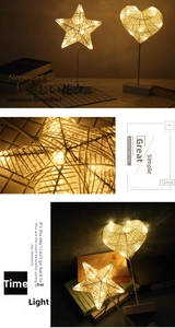 Detail of warm LED string lights inside star and heart shaped woven rattan table lamps