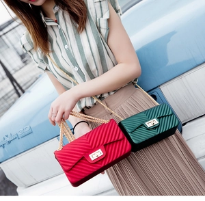 Detail of matte jelly shoulder bags in red and dark green with V-shaped chevron pattern