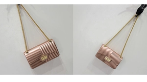 Detail view of rose gold V-quilted jelly crossbody bag with gold chain strap