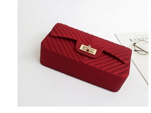 Close-up of red matte jelly bag featuring quilted V-pattern and gold-tone twist lock