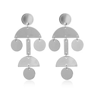 Detail of silver geometric tiered earrings featuring stacked circular and rectangular plates