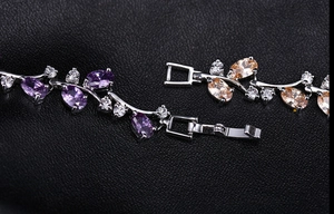 Detailed macro view of silver floral bracelet with purple zircons and folding clasp