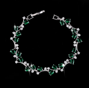 Macro shot of 18K white gold plated bracelet with emerald green stones and white zircons