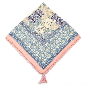 Detail of bohemian floral patchwork scarf with pink tassel fringe and ethnic patterns