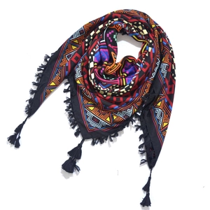 Detailed view of bohemian floral jacquard patterns and black fringe on an ethnic scarf
