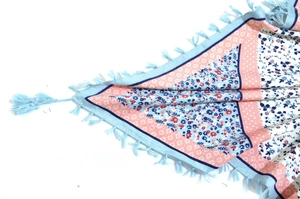 Detail shot of bohemian floral scarf fabric with vibrant blue tassels and patterned weave