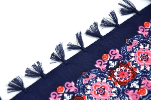 Detail shot of navy bohemian scarf with ethnic jacquard patterns and blue tassel fringes