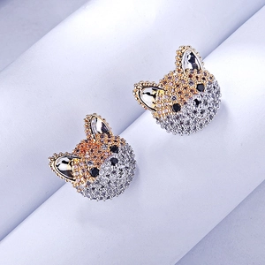 Macro view of cute dog stud earrings with white and yellow zircon pavé setting