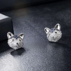 Macro view of animal-shaped silver studs featuring blue and white zircon pavé setting