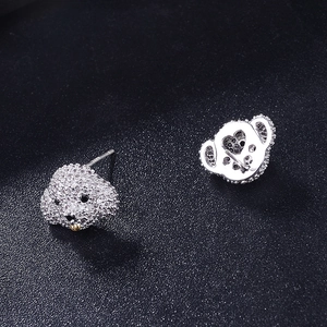 Detailed view of silver puppy stud earrings with white zircons and black gemstone eyes