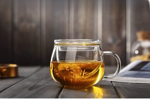 Detail of high borosilicate glass tea cup with infuser showing chrysanthemum tea