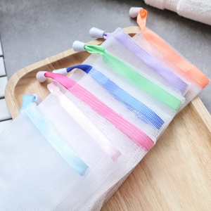 Double-layer nylon mesh foaming bags with colorful drawstrings on wooden tray