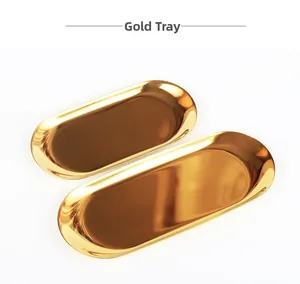 Detail of two gold oval stainless steel trays with a polished mirror finish for jewelry