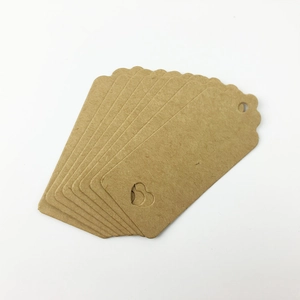 Macro shot of brown kraft paper gift tags with scalloped edges and heart-shaped cutout