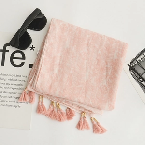 Detailed close-up of pink feather print cotton linen scarf with soft fringe and tassels
