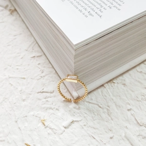 Detail of gold open ring with rectangle zircon stone and beaded texture on band