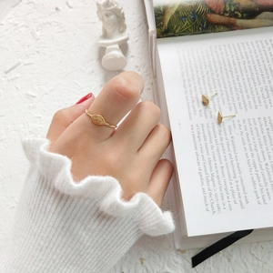 Close-up of vintage golden eye ring and earrings set on an elegant white book