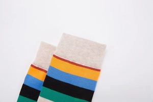 Detailed shot of knitted striped socks featuring colorful ribbed cuffs and cotton texture