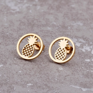 Minimalist gold pineapple stud earrings set on a textured stone grey background
