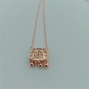 Detailed view of a rose gold longevity lock pendant with hollow design and three small bells