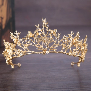 Couronne baroque dorée élégante avec papillons en cristal sur fond de bois sombre
