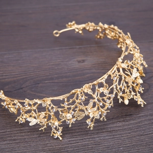 Détail d'une couronne baroque dorée avec motif de feuilles ajourées et strass brillants