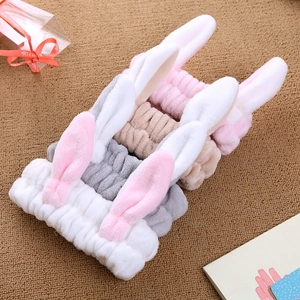 Macro detail of plush cat ear headbands in four colors on a textured background