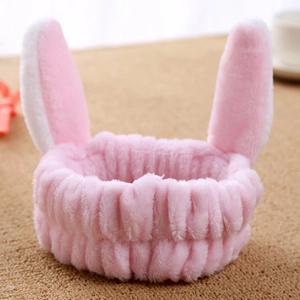 Close-up of a pink plush headband with cute bunny ears for skincare and face washing