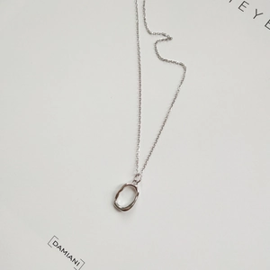 Macro detail of 925 sterling silver irregular liquid metal pendant and thin chain