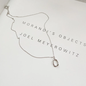 Detail shot of irregular organic 925 sterling silver pendant necklace on minimalist book