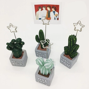 Detailed view of four cactus-shaped photo holders with gray cement bases and star clips