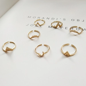 Set of 7 gold-colored geometric rings featuring moon, crown, and mountain shapes