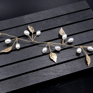 Detailed macro view of golden metal leaves and white pearls on bridal hair vine