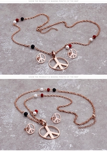 Macro detail of rose gold peace sign necklace and stud earrings set with colorful beads