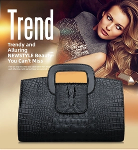 Detail of black crocodile-embossed handbag featuring a 3D crocodile head relief