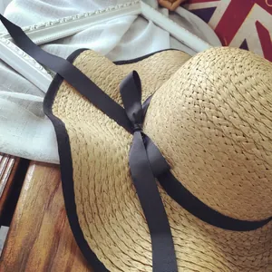 French retro straw sun hat with large brim and black ribbon bow for summer beach