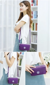 Paarse mini crossbodytas van nylon met meerdere ritsvakken en verstelbare riem