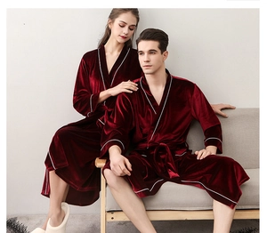 Close-up of luxury burgundy velvet couples robes with white trim and waist tie detail