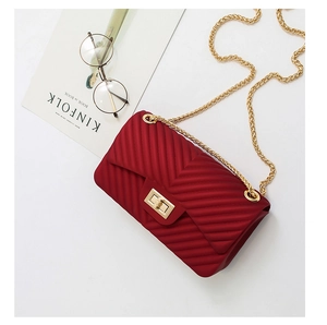 Close-up of red V-quilted chain bag with gold lock and matte texture finish