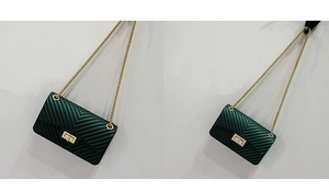 Detail of dark green V-quilted jelly bag with gold chain strap and rectangular metal lock