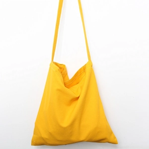 Detailed view of heavy canvas texture and stitching on the bright yellow tote bag