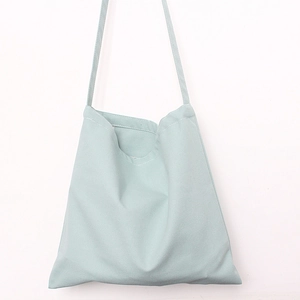 Close-up of mint green canvas tote bag fabric texture and shoulder strap details