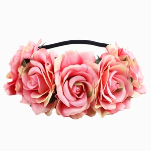 Close-up of five gradient pink silk roses on a flexible black elastic bohemian headband